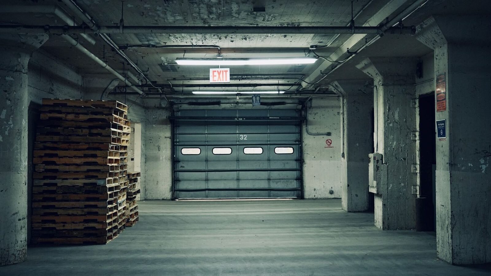 The inside of a garage with a closed sectional door and overhead structure