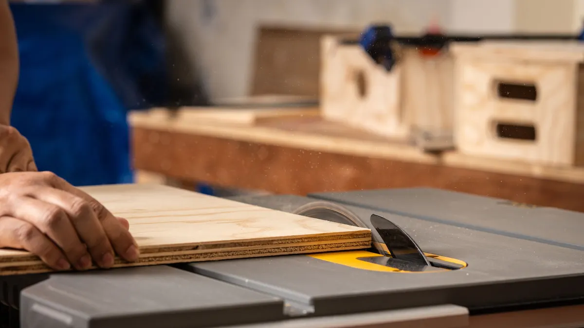 Board being fed into a table saw