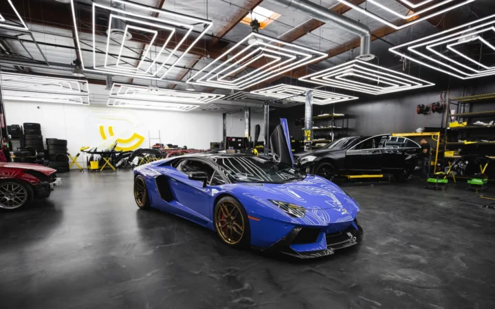 Glossy epoxy garage floor reflecting a blue sports car and shop lights