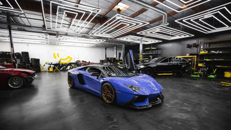 Glossy epoxy garage floor reflecting a blue sports car and shop lights