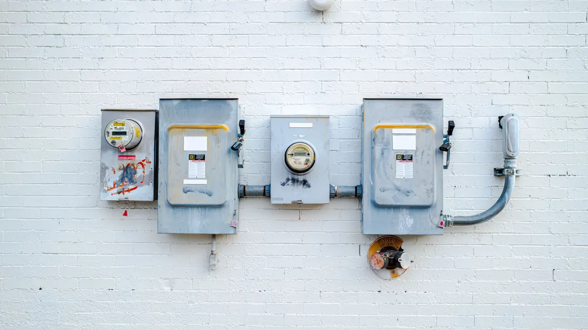 Electrical disconnects and meters mounted on a white brick wall