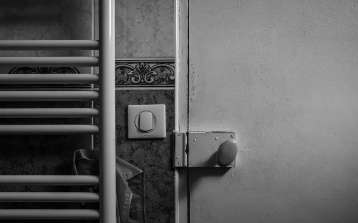 Wall-mounted heating panel beside a light switch on a gray wall