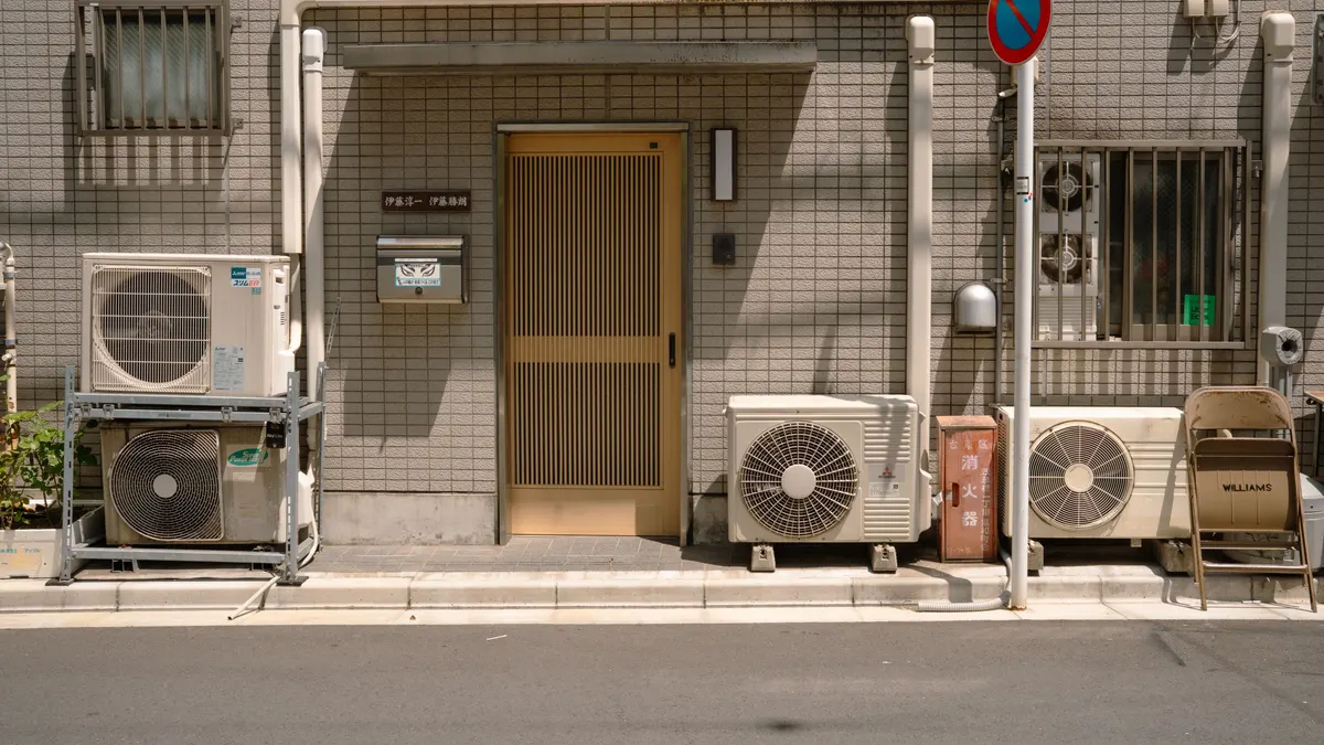 Outdoor air conditioner units beside a building entrance