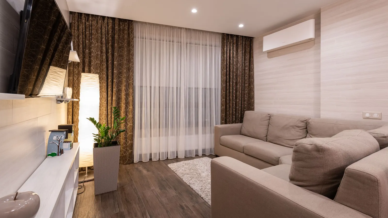 Living room with a wall-mounted mini split unit near the ceiling