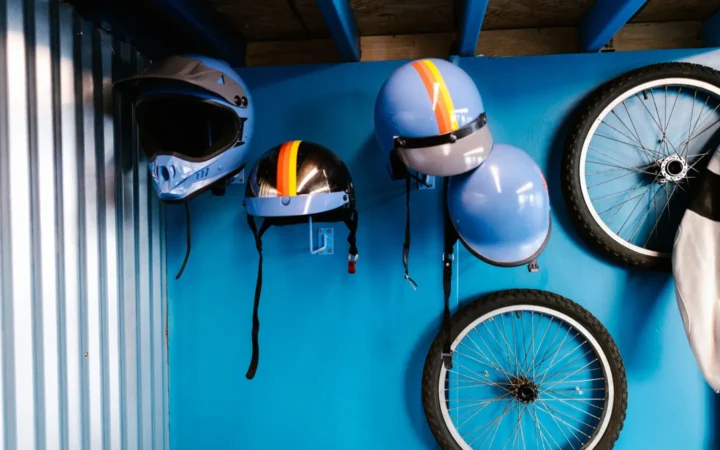 Bikes, wheels and helmets hanging on a blue wall