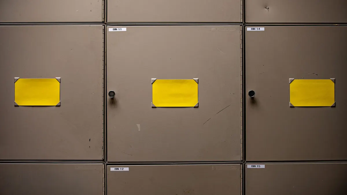 Row of metal storage cabinets with yellow labels