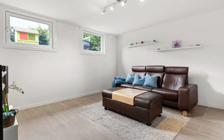 Bright living room with a leather sofa and a window