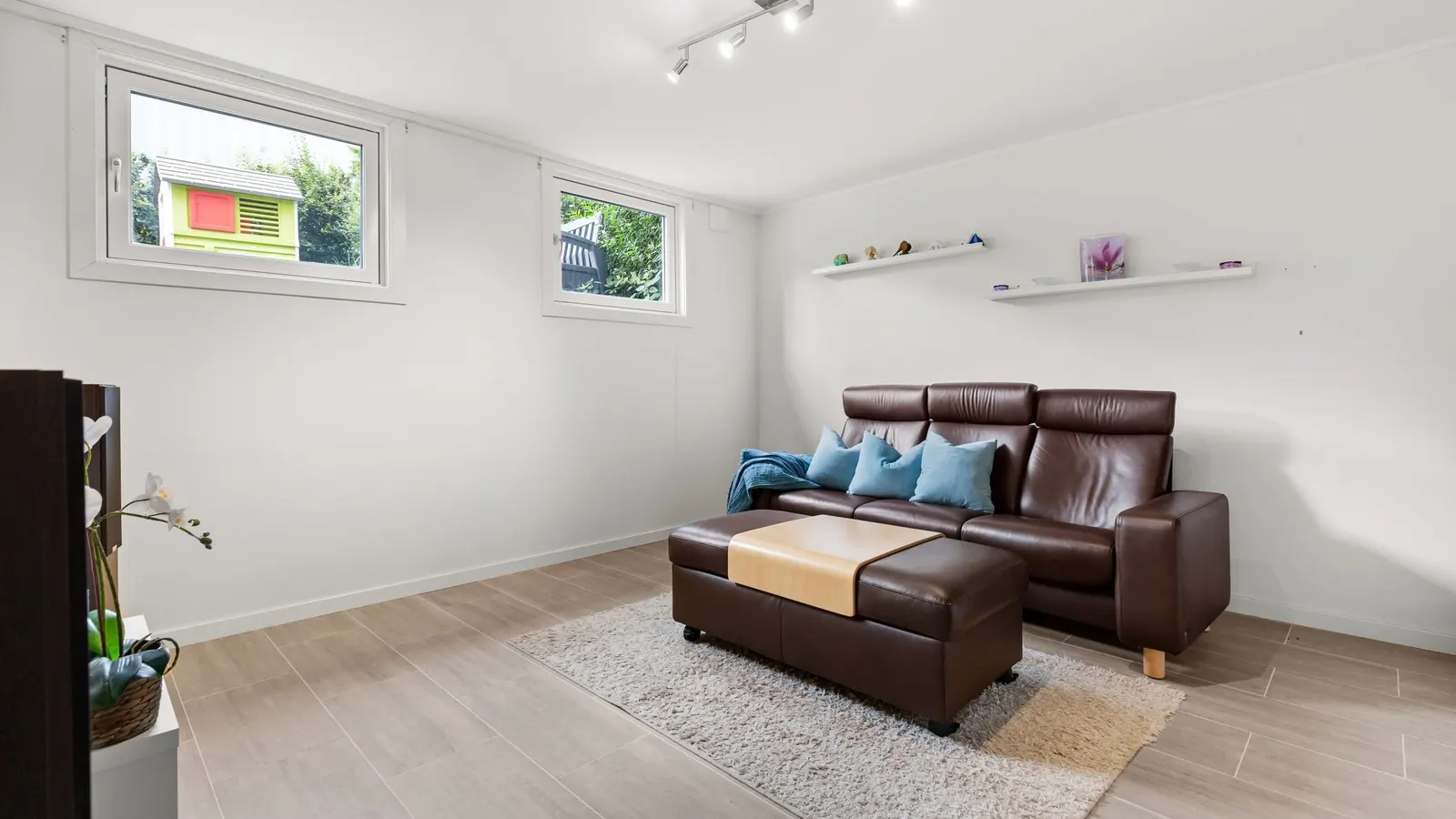 Bright living room with a leather sofa and a window