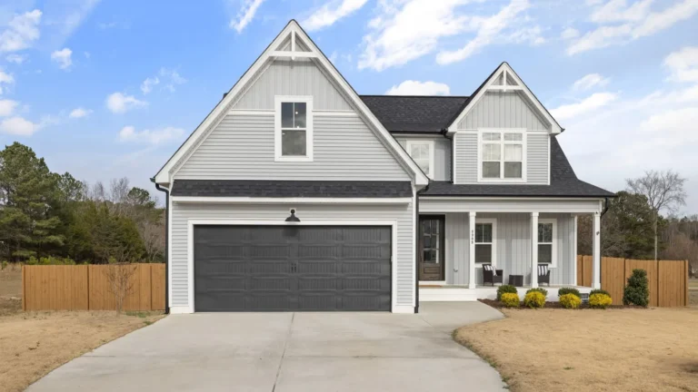 Gray two-story house with a dark double garage door and a concrete driveway