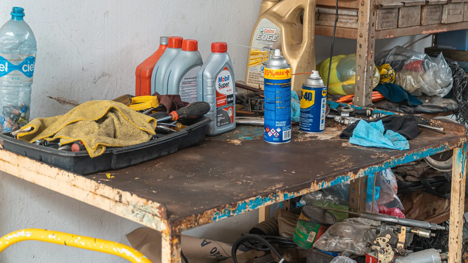 Workbench with oil bottles, spray lubricant cans and work gloves