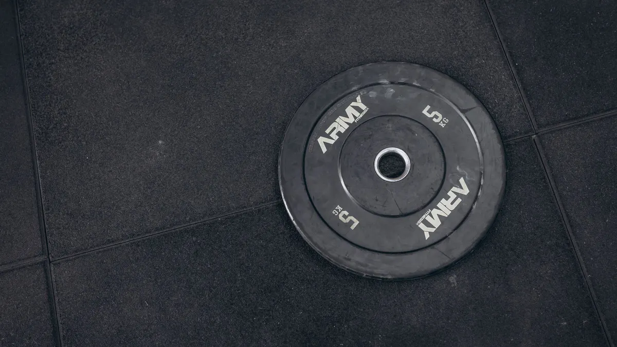 Bumper plate lying on a rubber gym floor