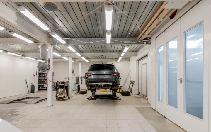 Bright garage with rows of LED ceiling lights and a raised car