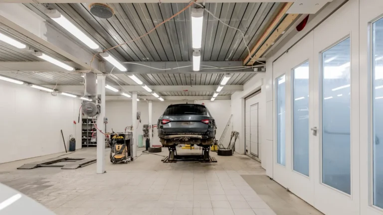 Bright garage with rows of LED ceiling lights and a raised car