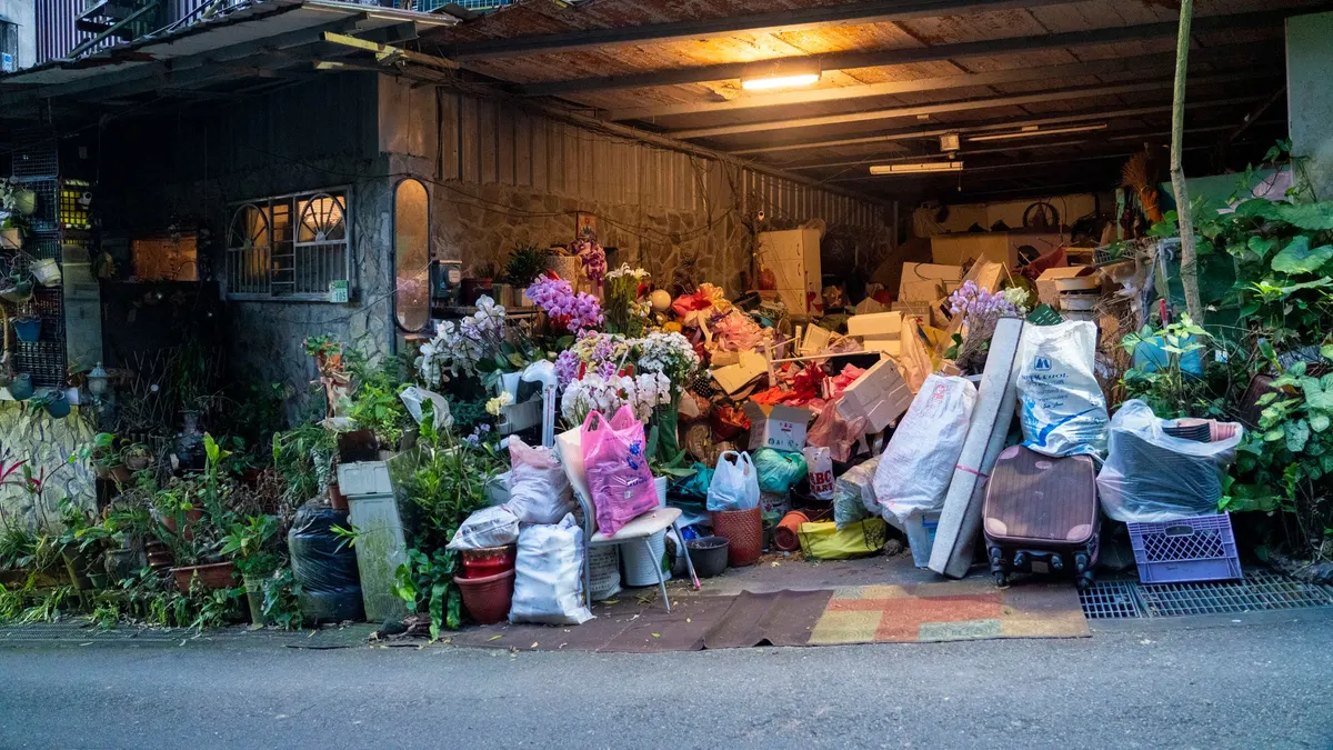 Cluttered garage filled with boxes, bags and plants