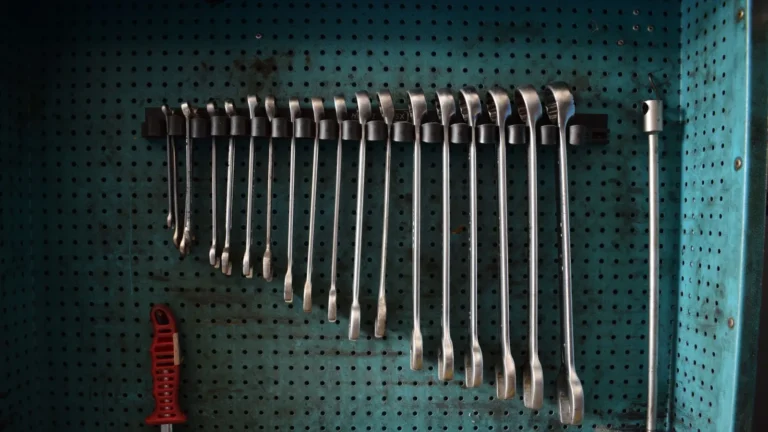 Wrenches hanging in size order on a teal pegboard