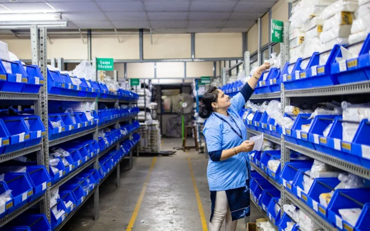 Person organizing blue bins on long metal shelving units