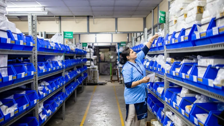 Person organizing blue bins on long metal shelving units