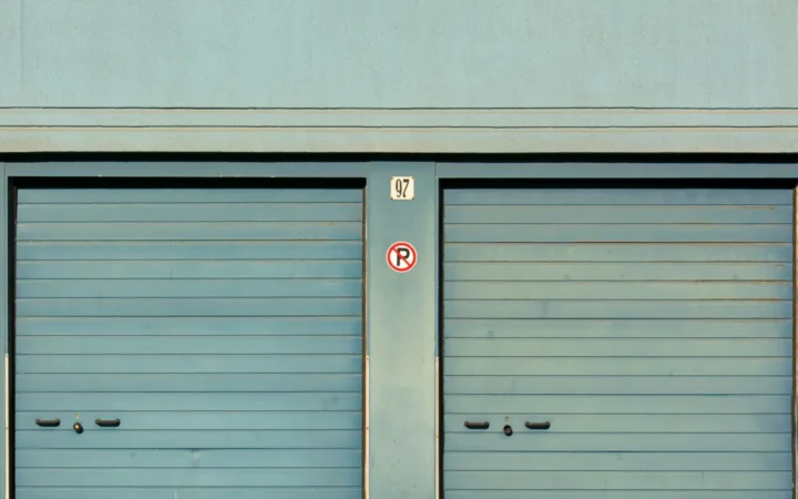 Two teal sectional garage doors side by side