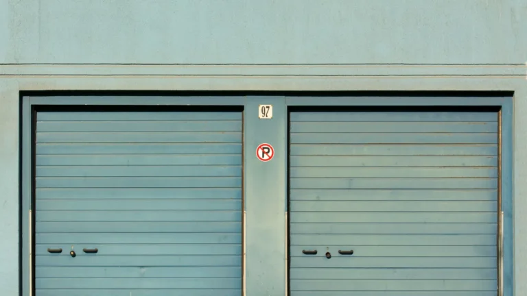 Two teal sectional garage doors side by side