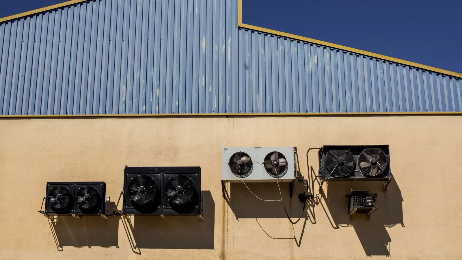Exhaust fans mounted high on the wall of a building