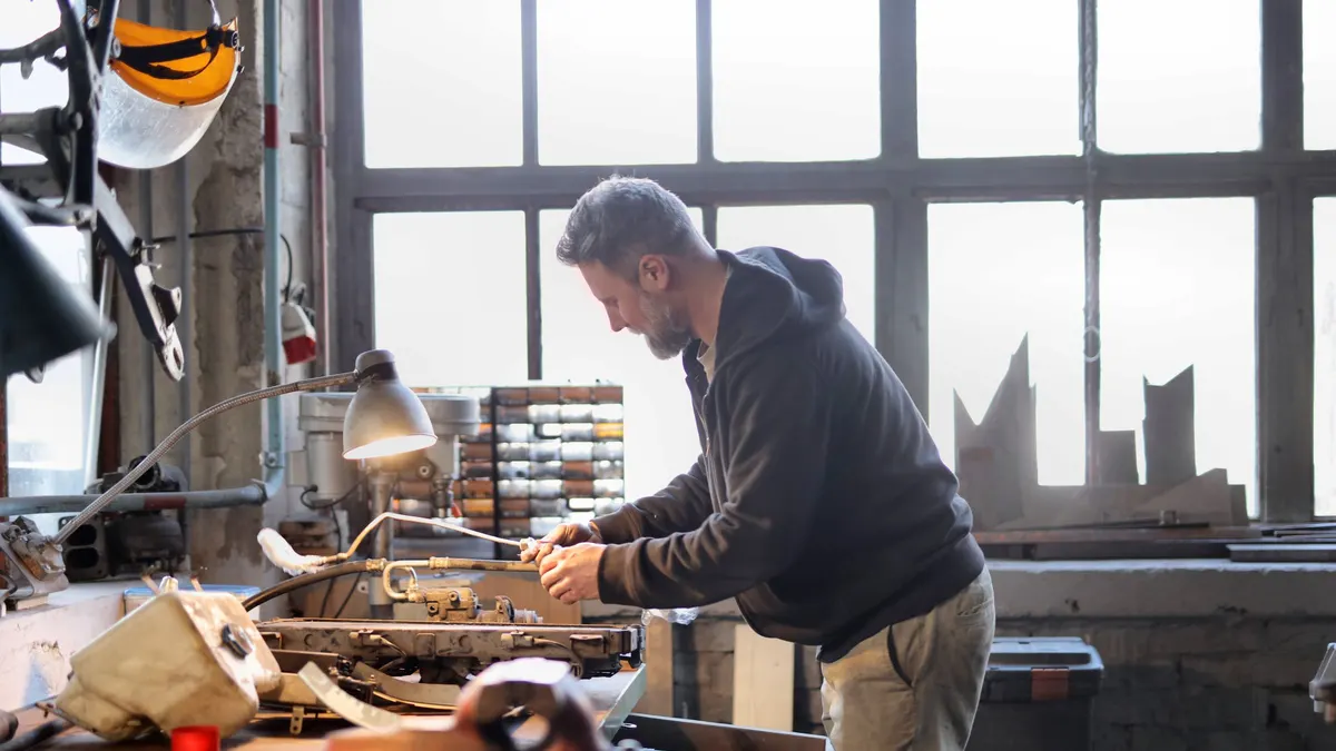 Man working at a bench under a window in a workshop