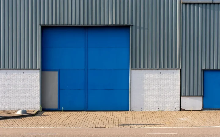 Blue roll-up door in a gray metal building