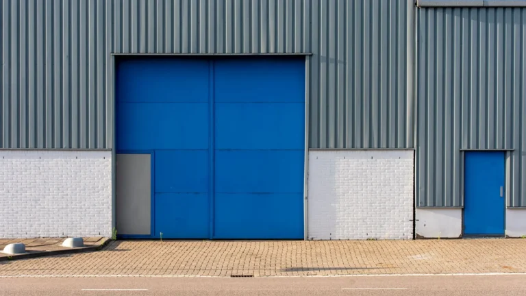 Blue roll-up door in a gray metal building