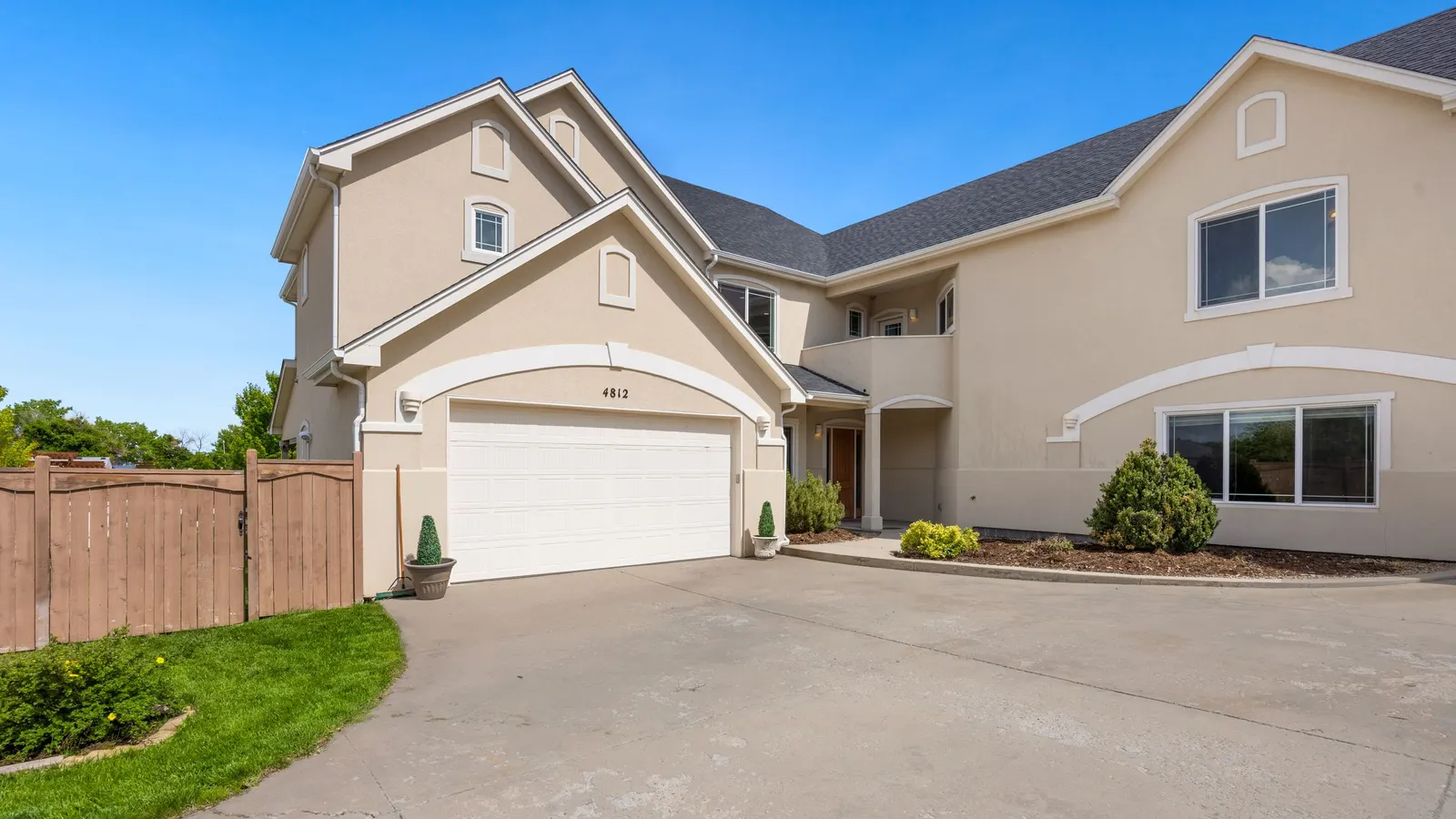 Modern house with a white sectional garage door and a wide concrete driveway