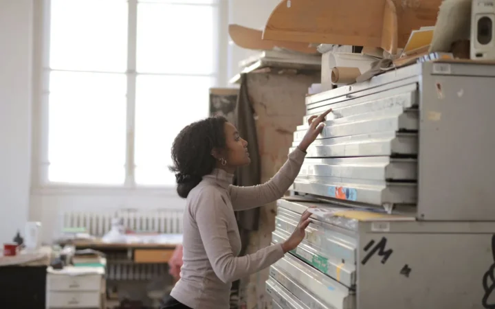 Woman opening a drawer in a tall metal drawer cabinet