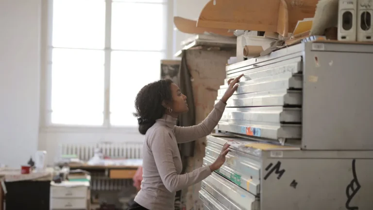 Woman opening a drawer in a tall metal drawer cabinet