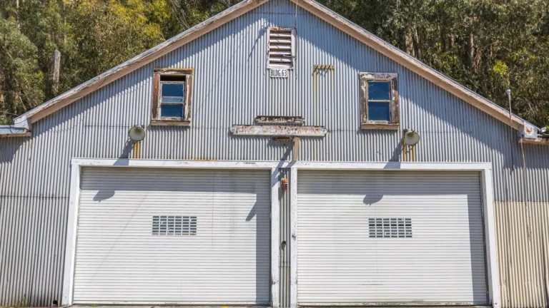 Gray building with two white single garage doors