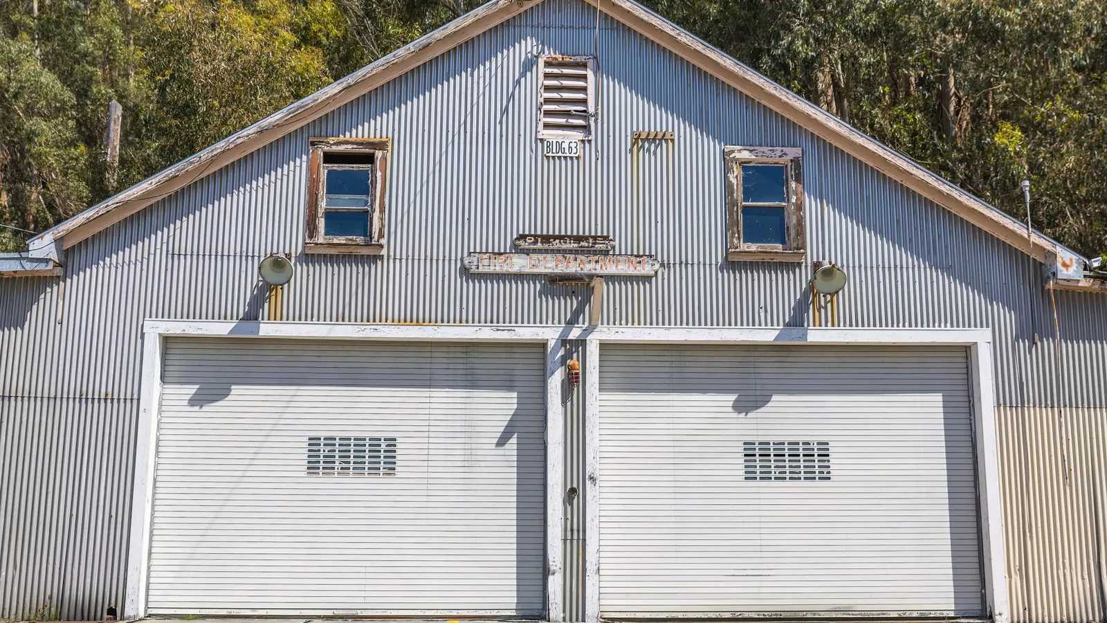 Gray building with two white single garage doors