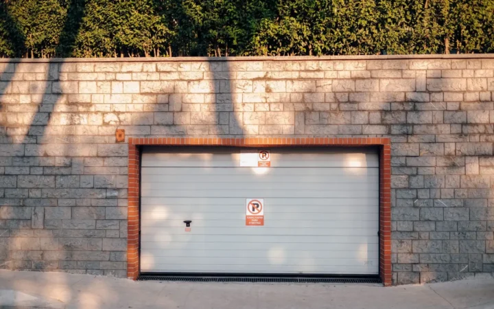 Closed white sectional garage door set in a brick wall