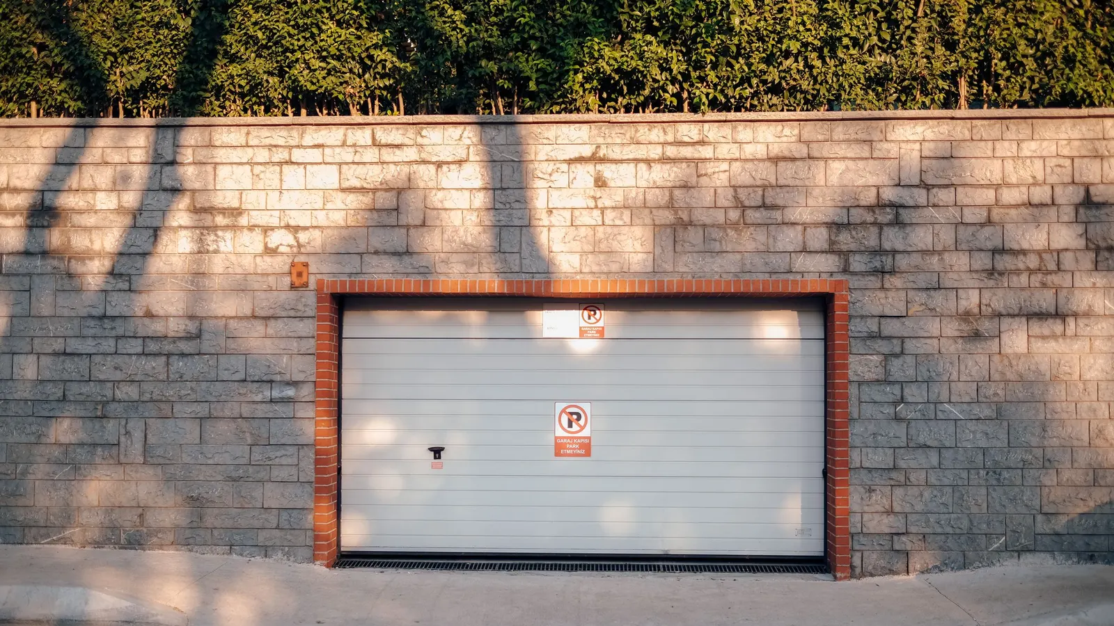 Closed white sectional garage door set in a brick wall
