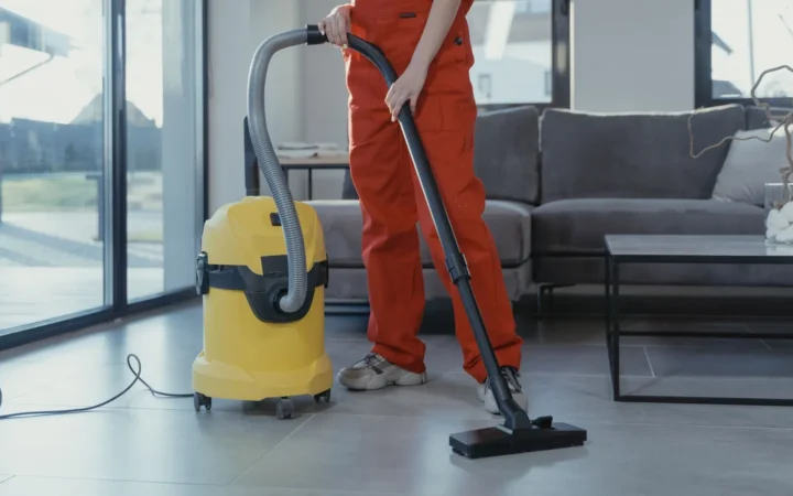 Person cleaning with a yellow wet and dry shop vac